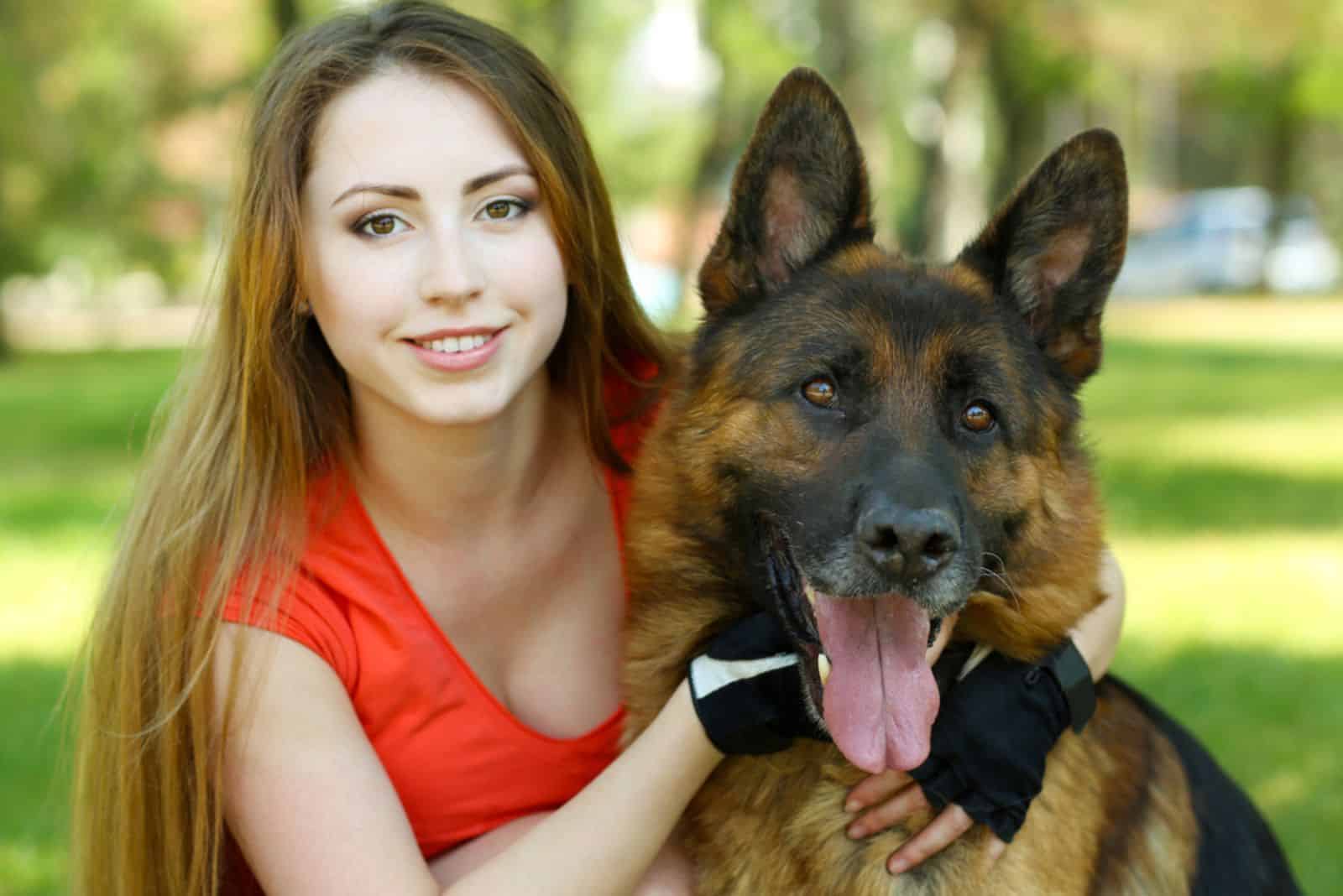 smiling woman embracing her dog in the park