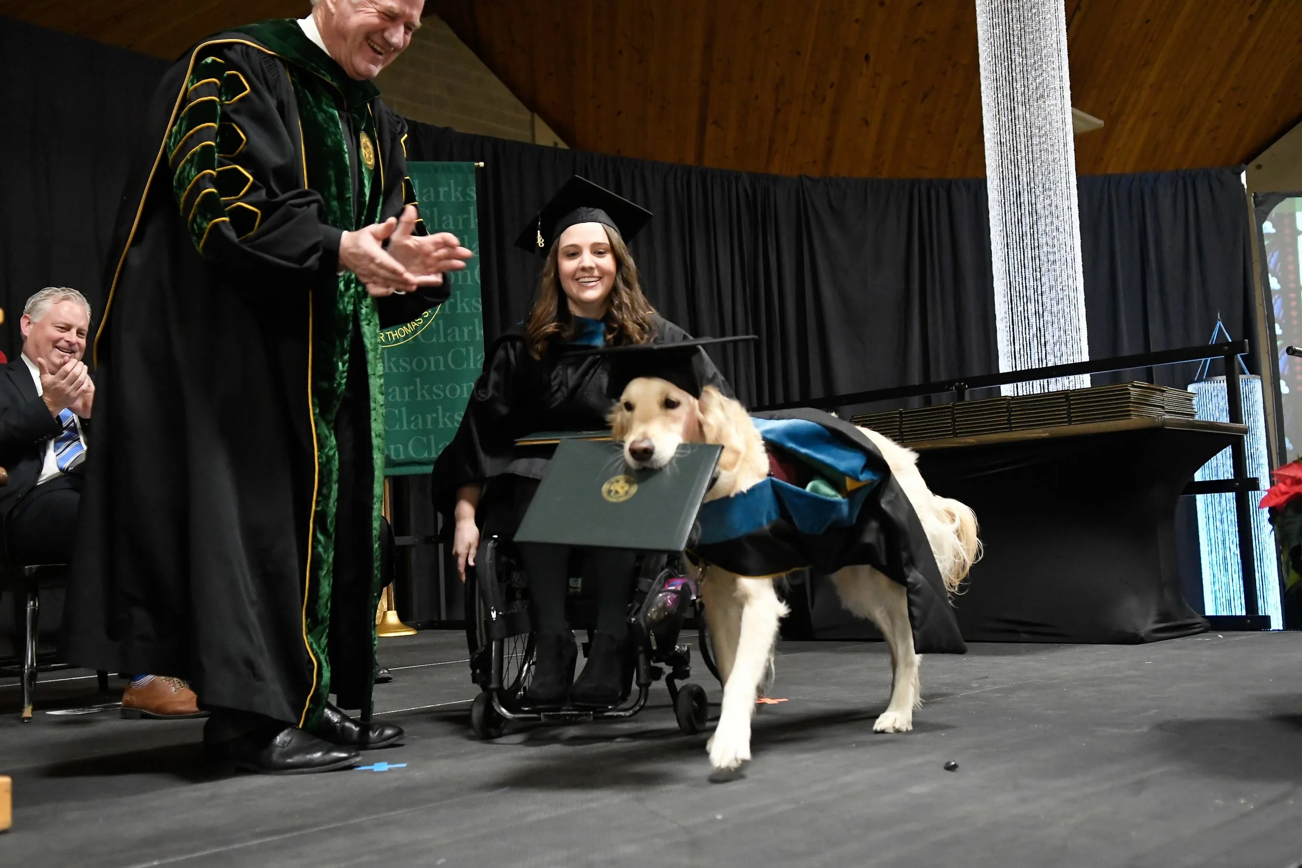 the dog carries the diploma in its mouth