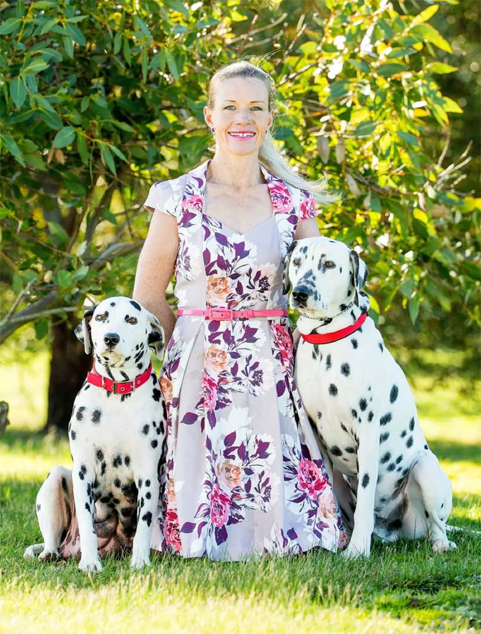 woman with her two dalmatian dogs in the park