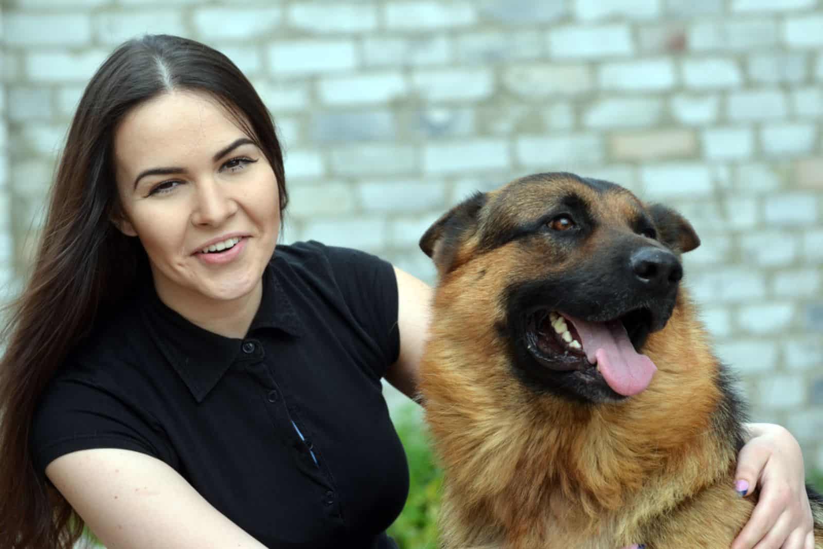 young woman embracing her dog in the garden