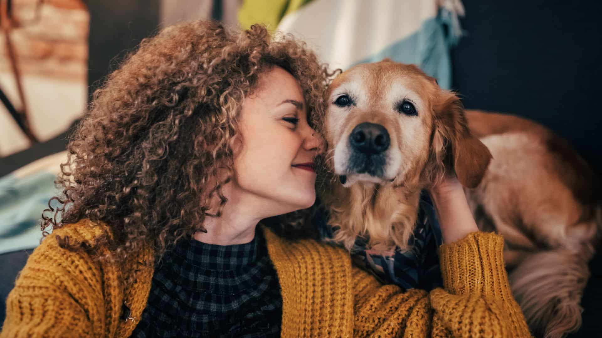 photo of woman hugging a golden retriever