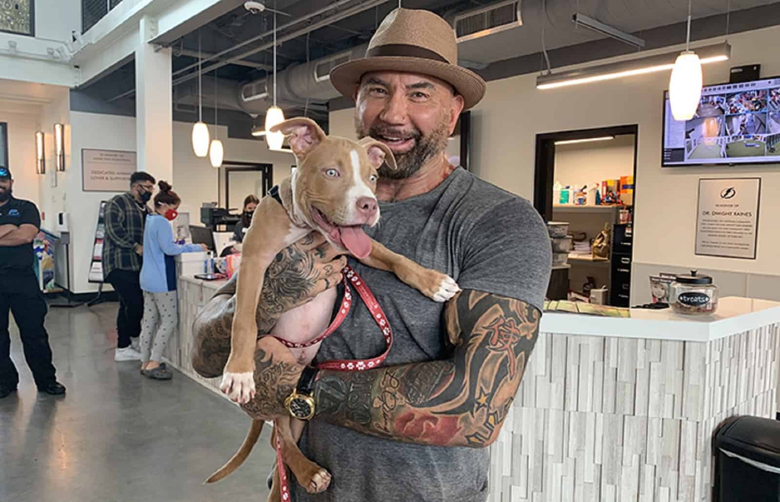 Dave Bautista holding pitbull dog in his arms