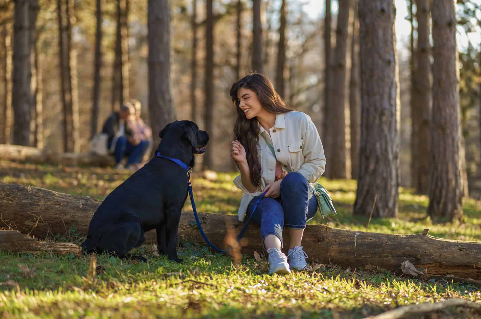 Woman sitting with her dog in the woods