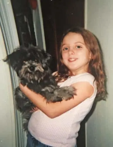 little girl holding her dog in her arms