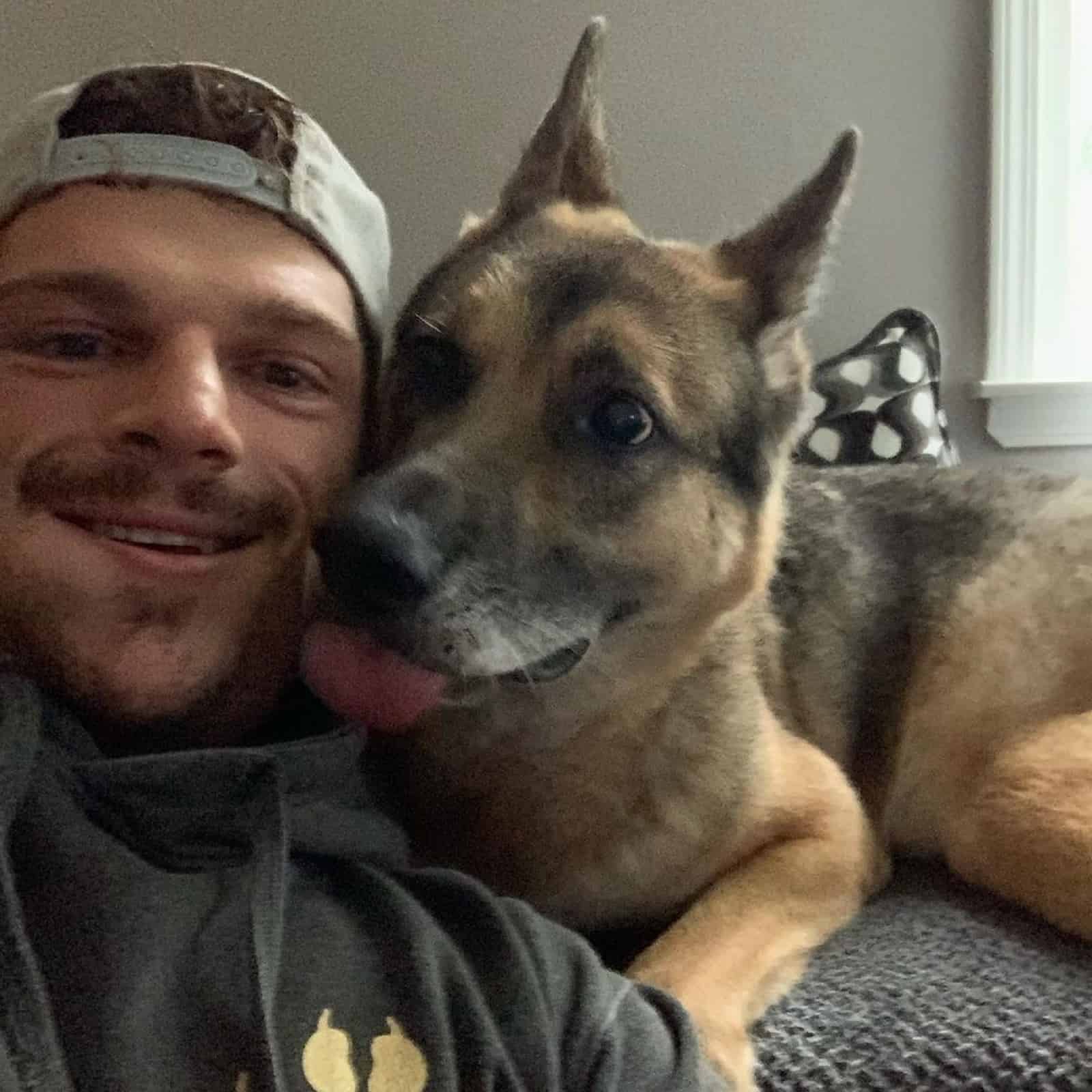man and german shepherd dog on the couch