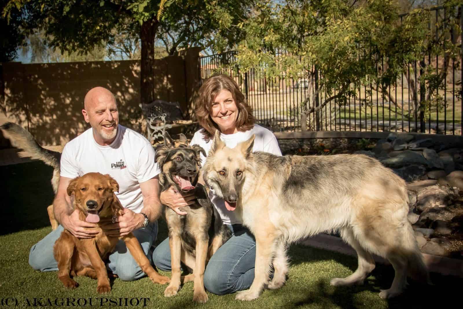 man and woman with their dogs in the yard