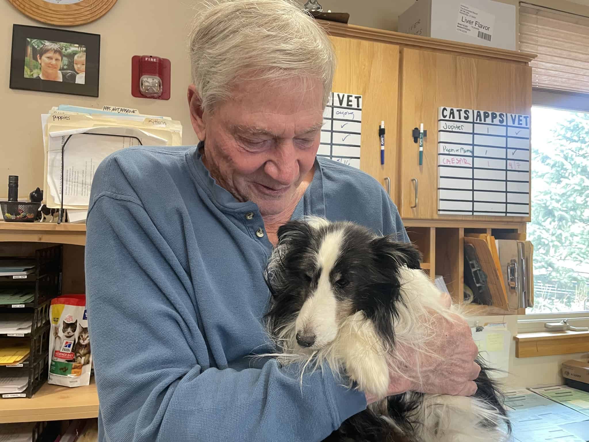 old man holding adopted dog