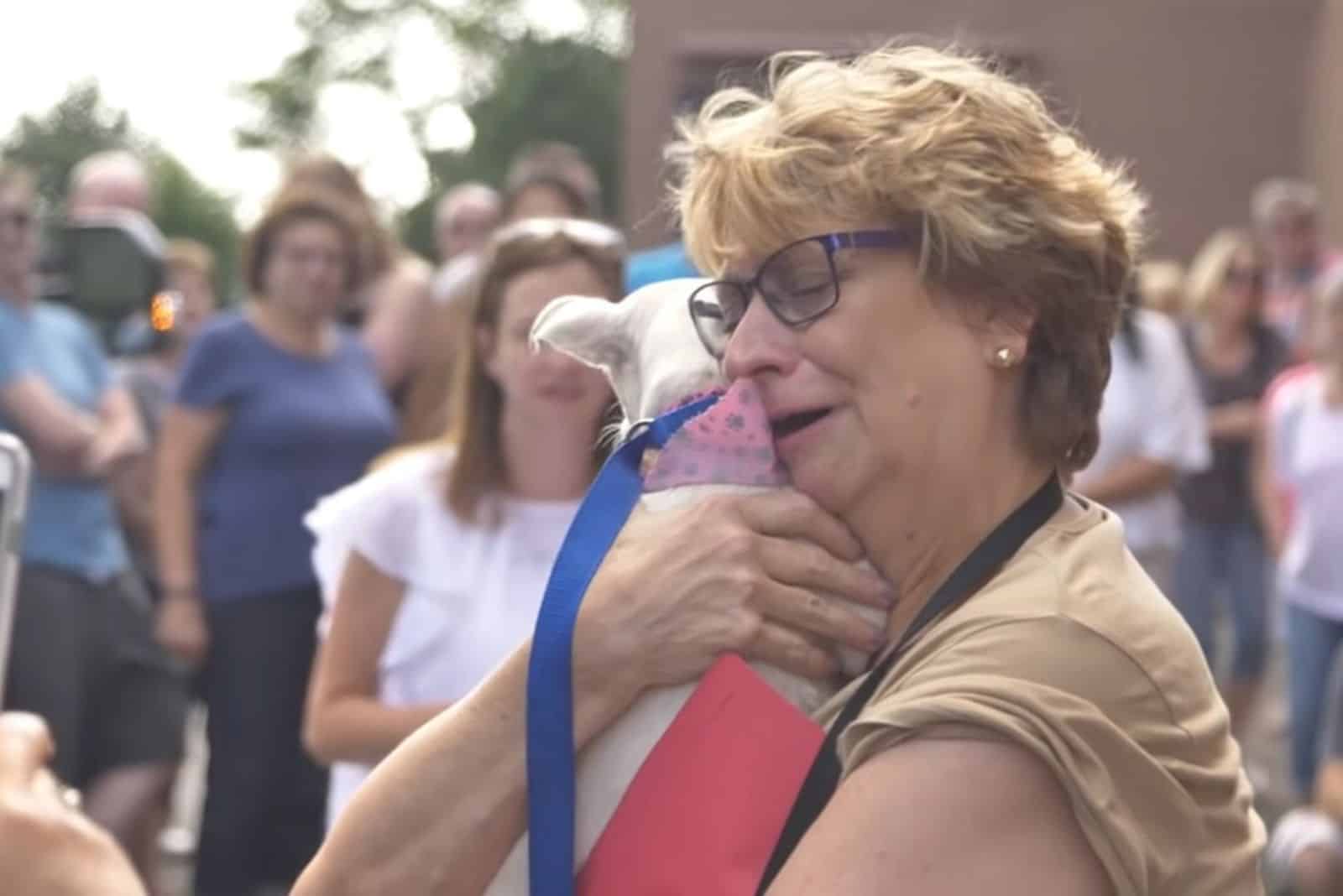 photo of a dog in the arms of his new owner