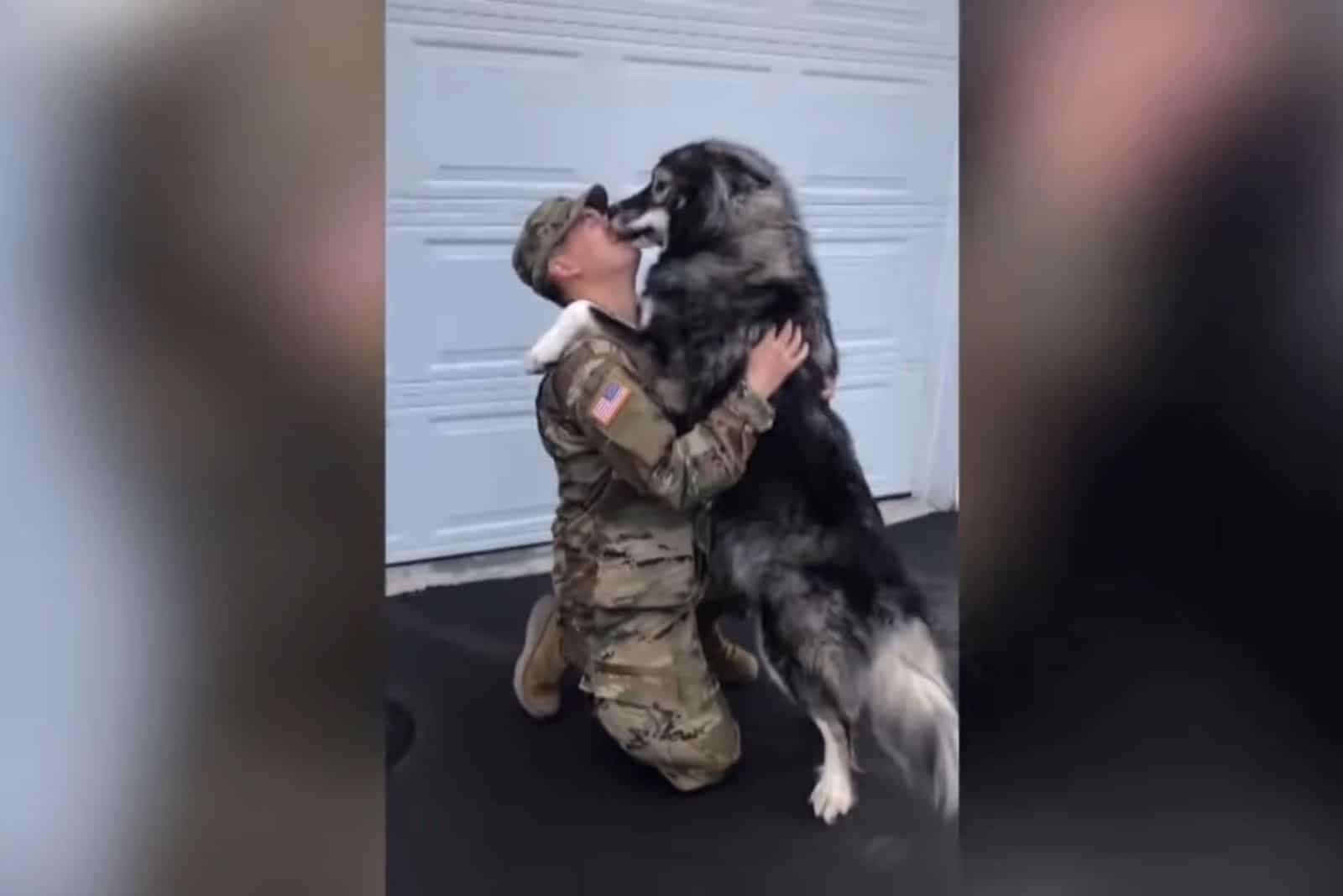 soldier and dog hugging each other in front of the house