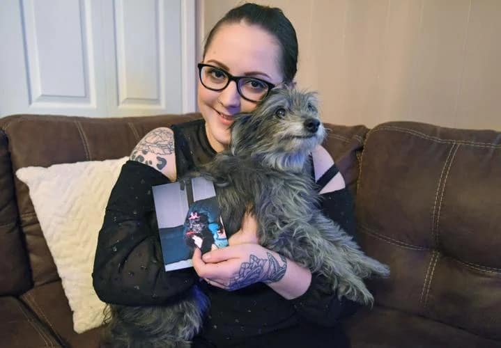 woman holds her dog in a lap