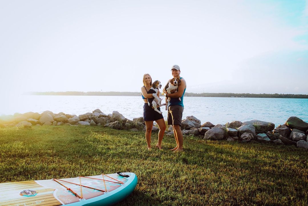 couple posing with dogs in their hands