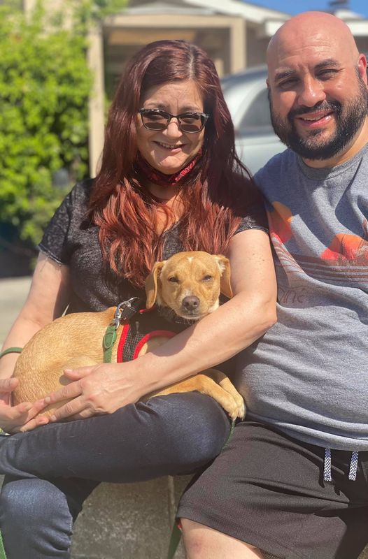 man and woman holding the adopted dog