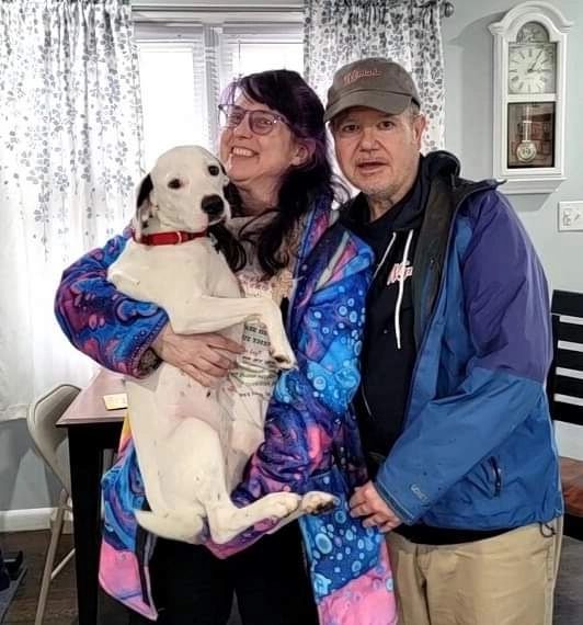 photo of man and woman holding a dog