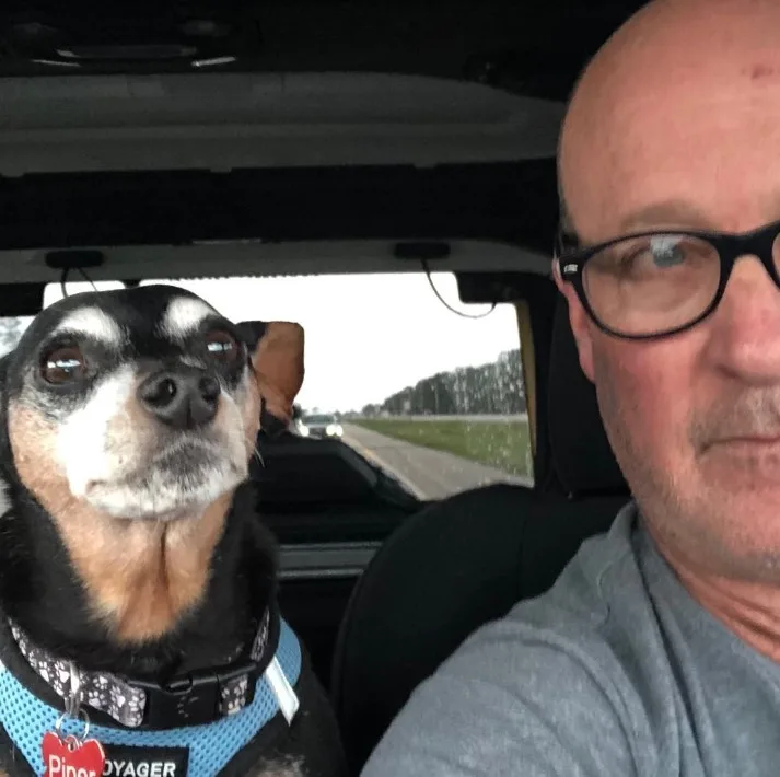 retrato de un hombre y un perro mirando a la cámara