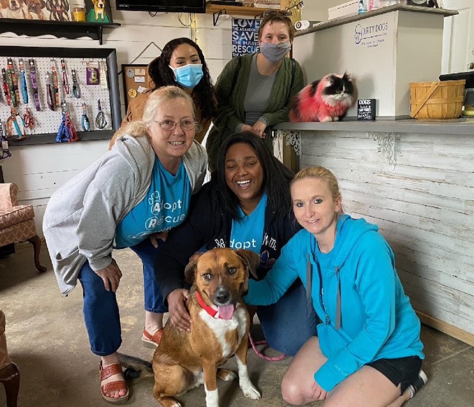 smiling friends take a picture with a dog