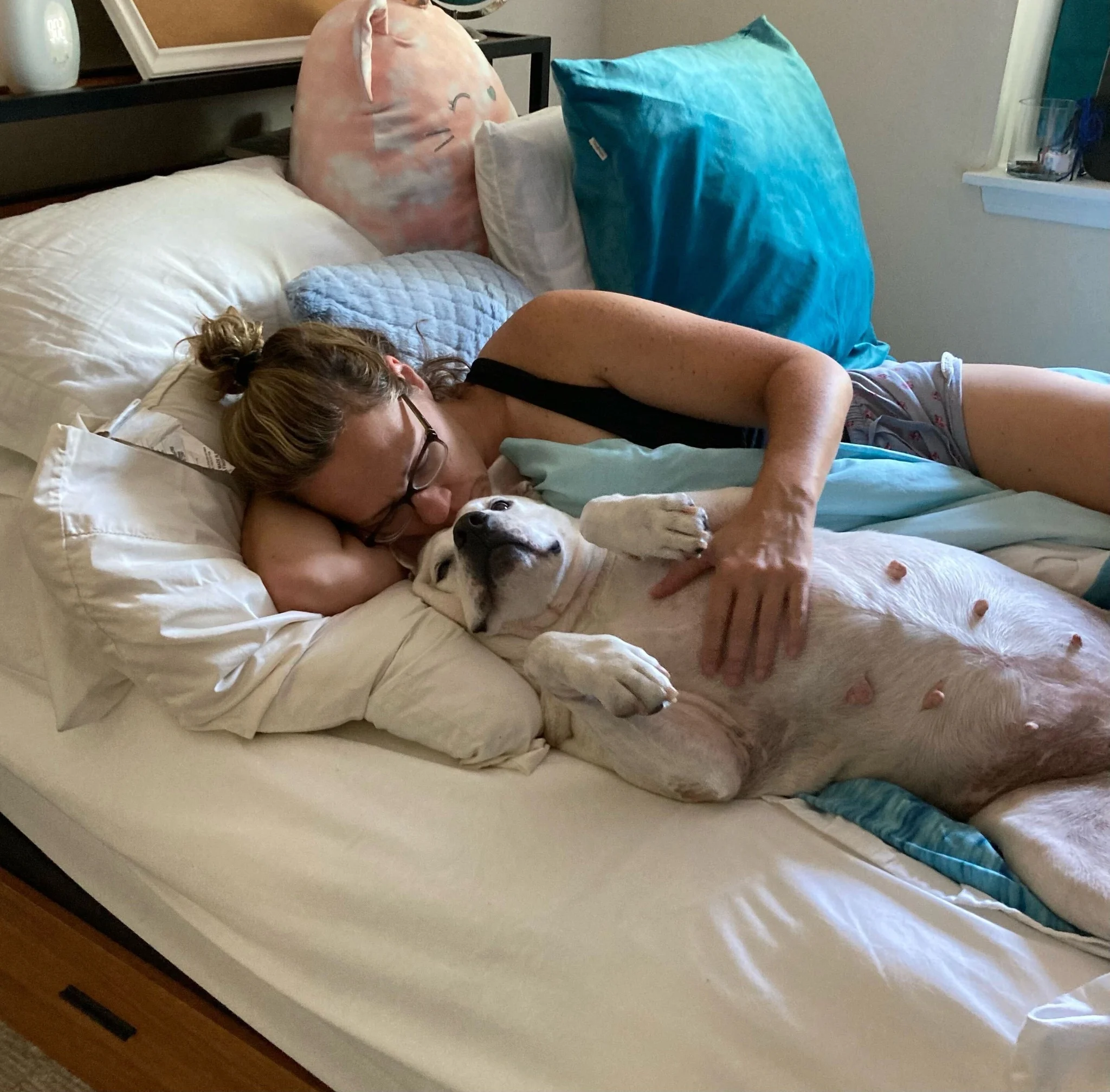 mujer acostada con perro en la cama
