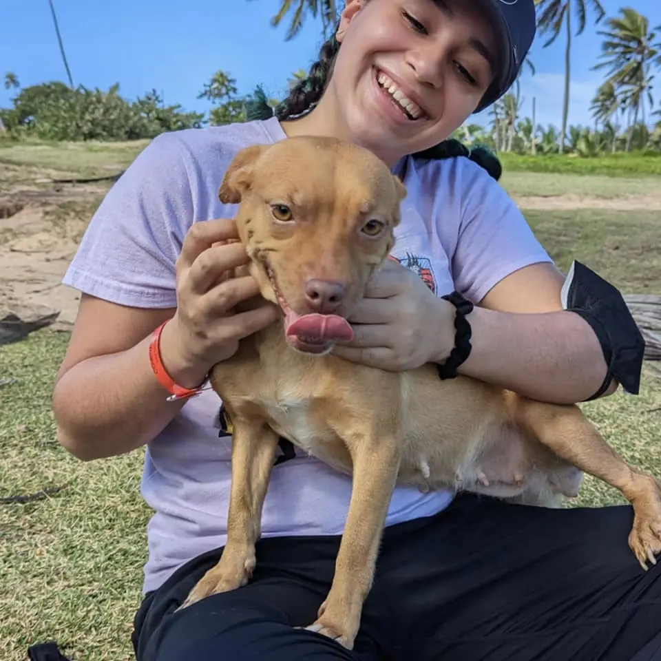 mujer sonriendo y sosteniendo un perro
