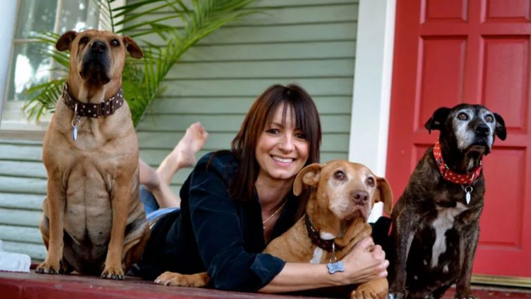 woman with her three dogs in front of the house