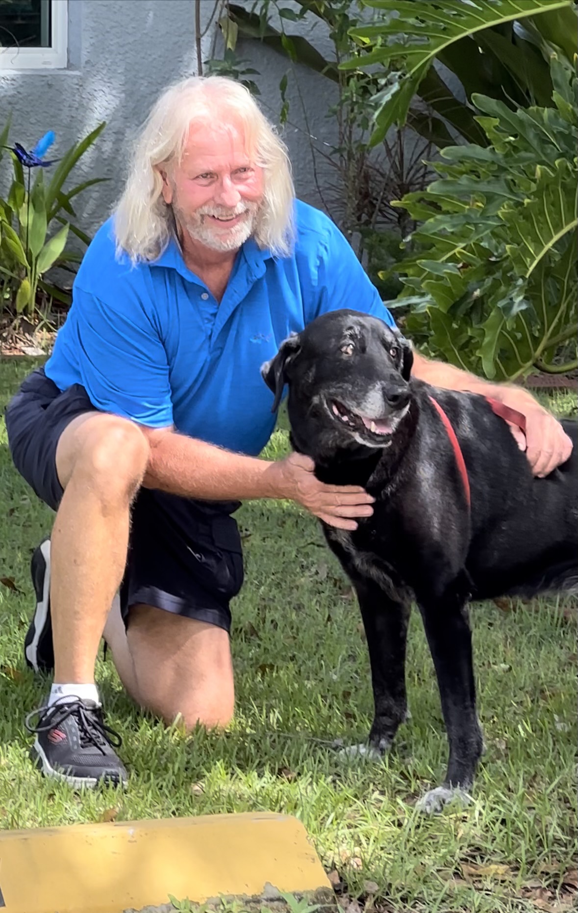 Old guy hugging his black dog