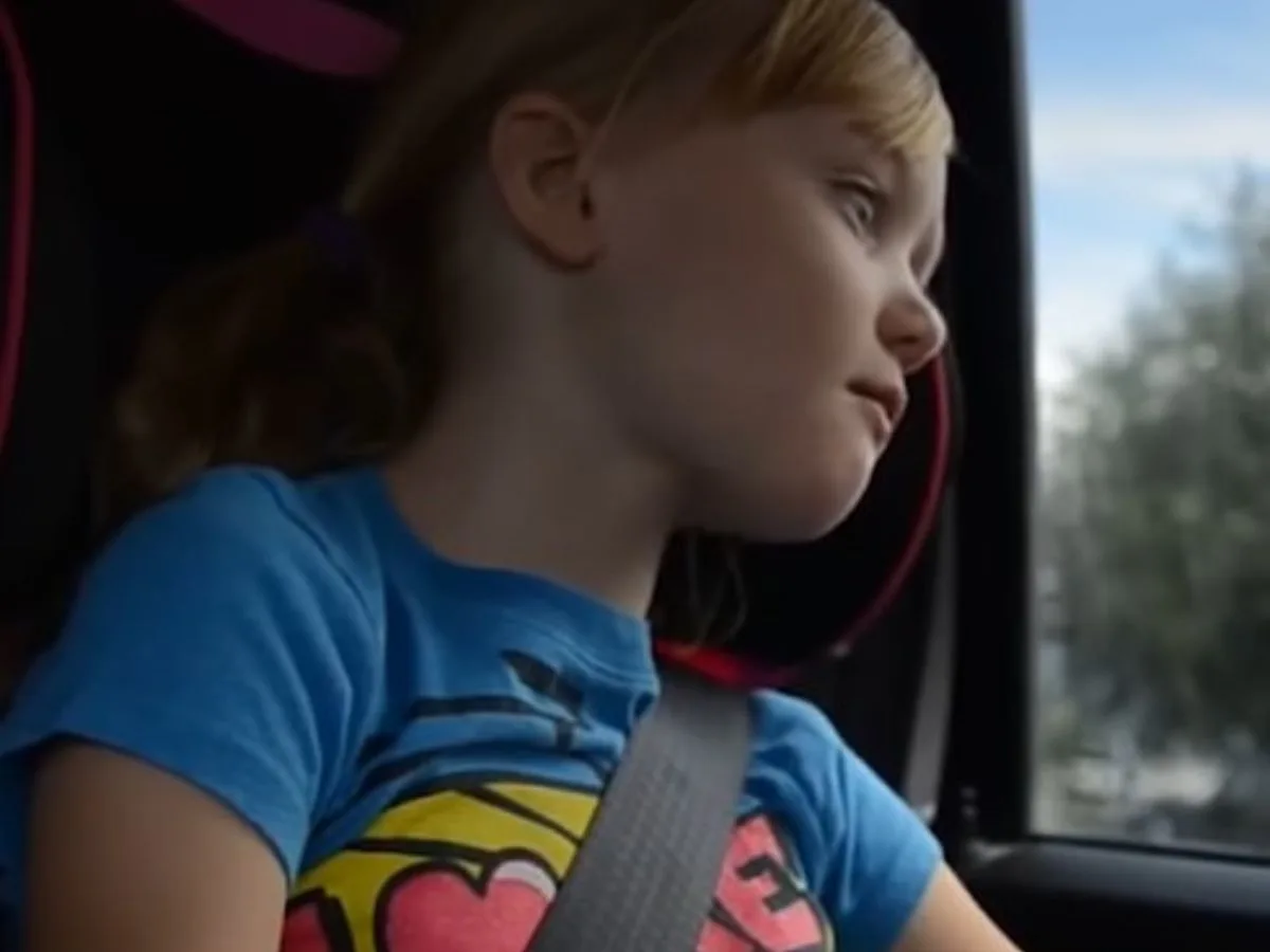 little girl looking through car window