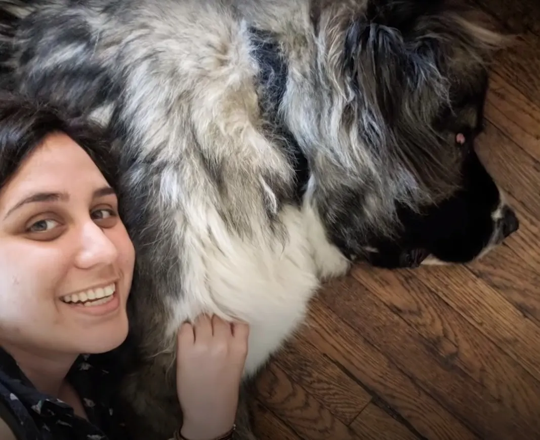 smiling woman hugs her shaggy dog