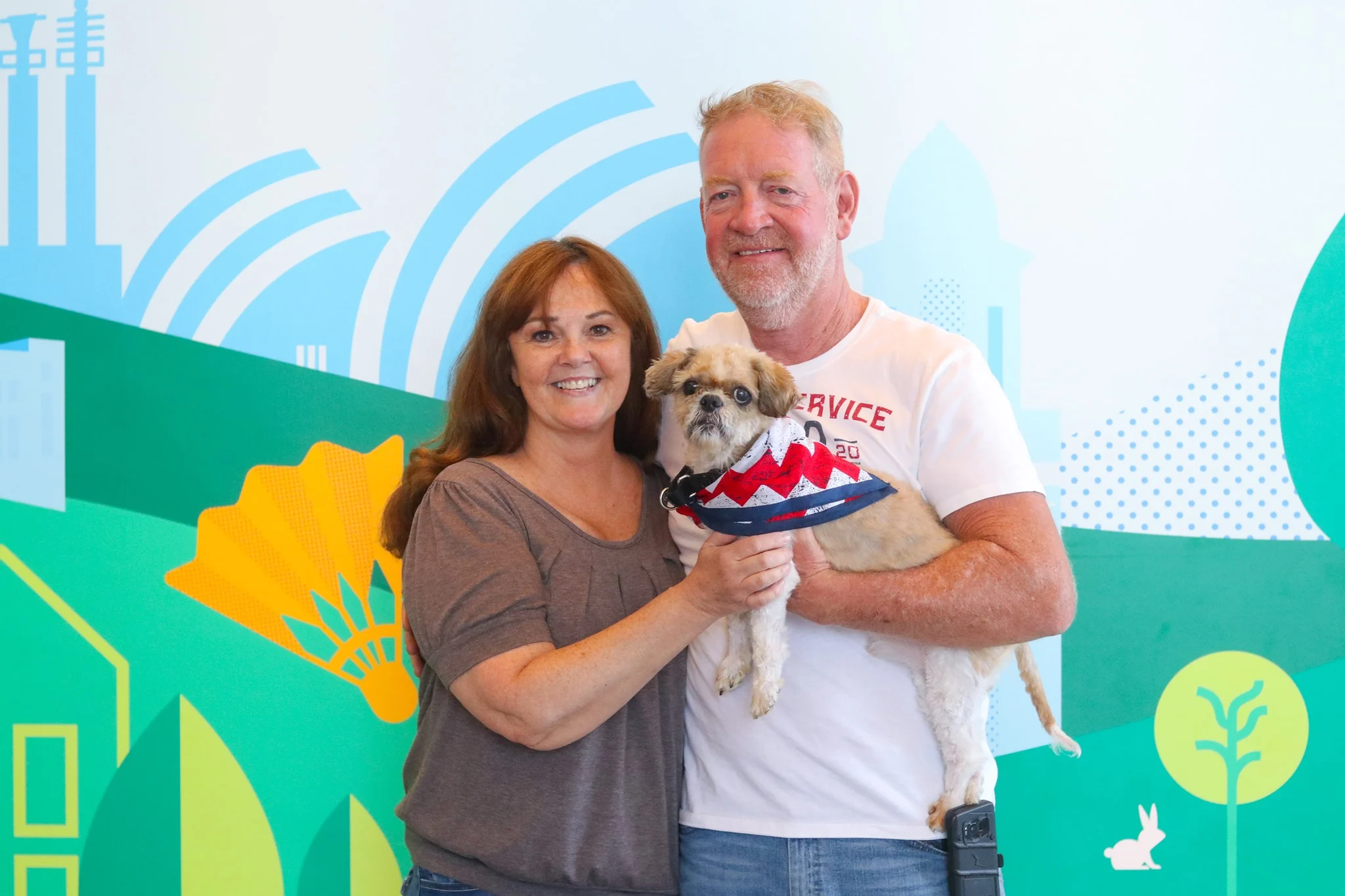 woman and man holding a dog