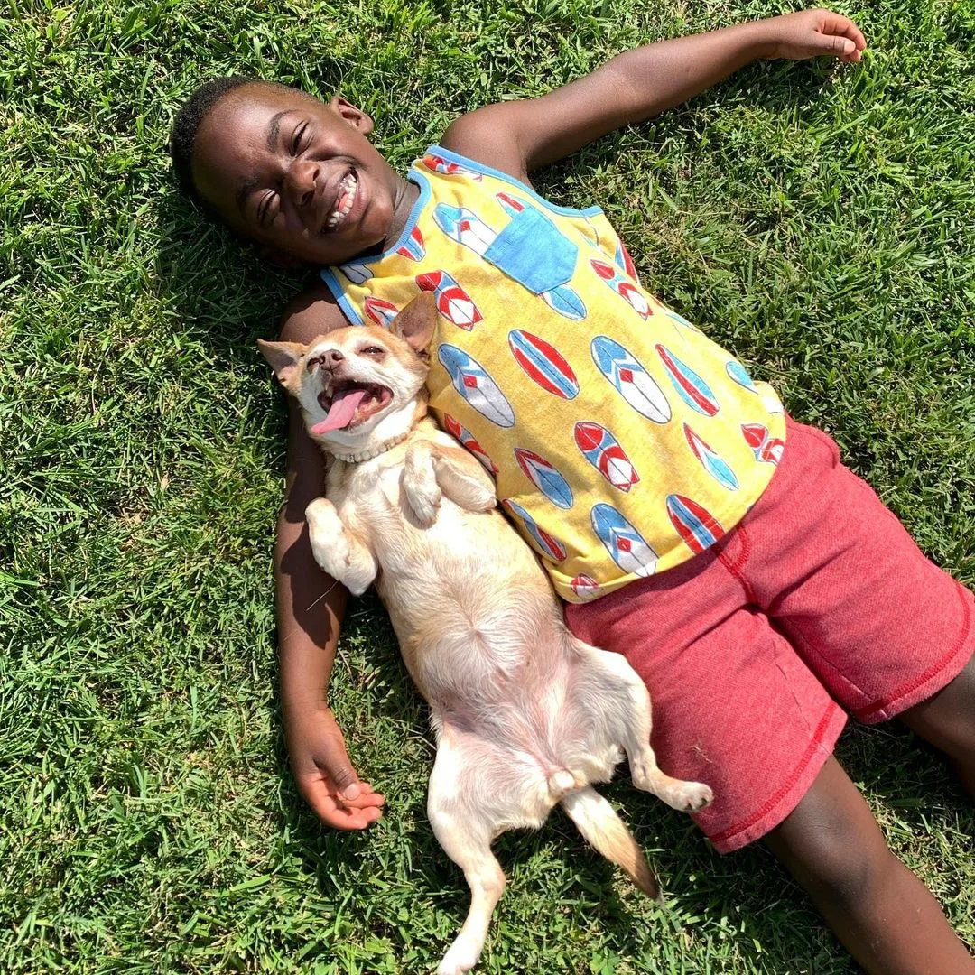 Kid and dog laying on the ground