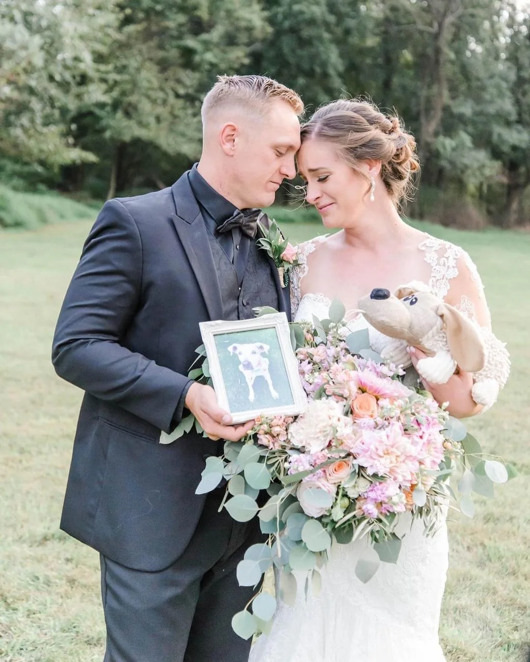 couple holding a photo of a dog at wedding