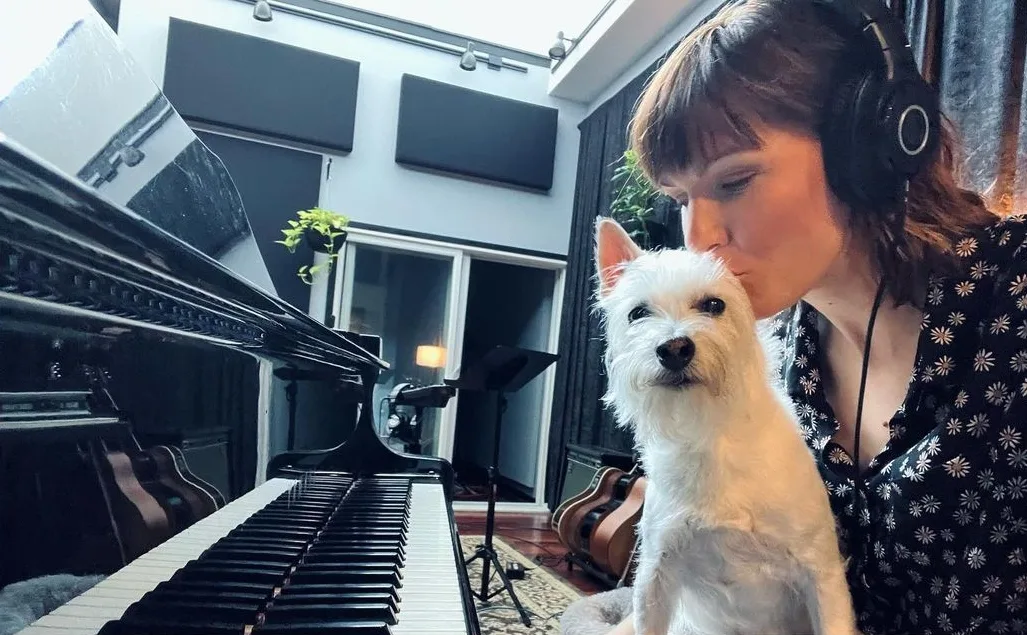female musician kissing a dog