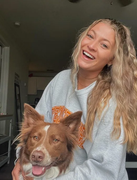 smiling girl and dog pose in front of the camera