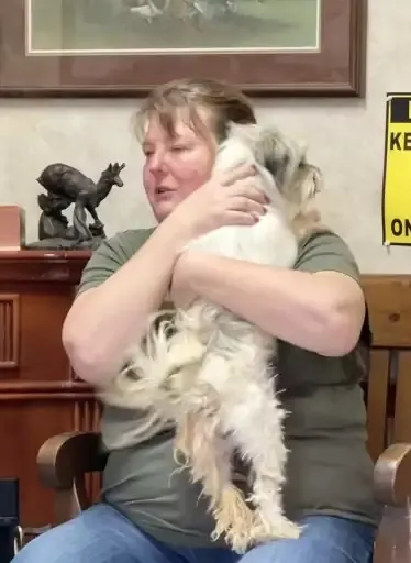 woman hugging a little white dog