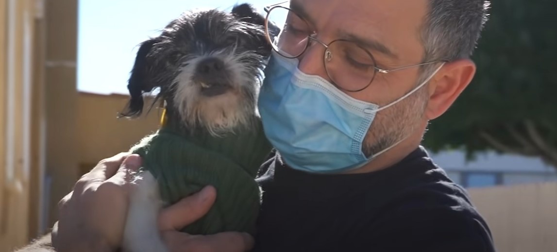 man with mask holding puppy