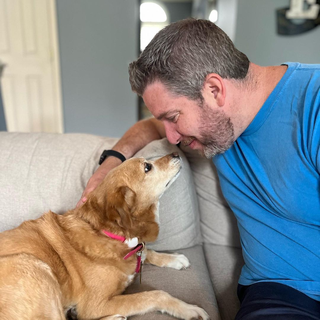 owner and dog sitting and staring at each other