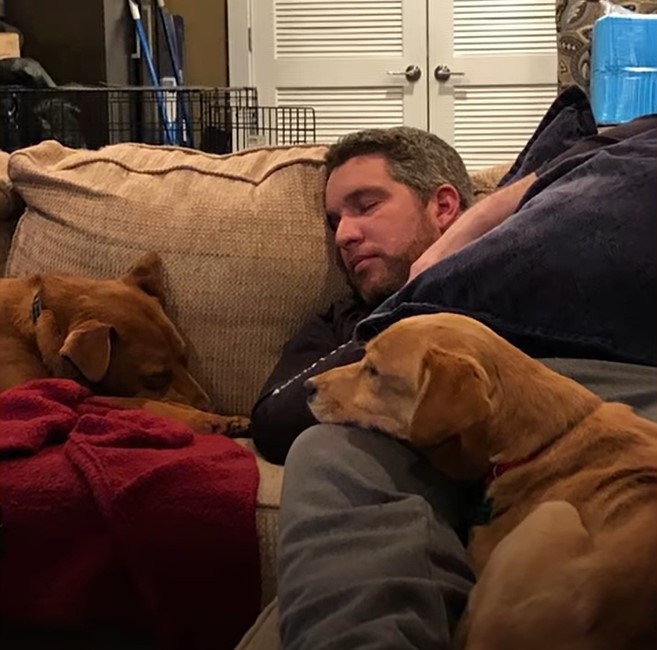 owner sleeping with two dogs