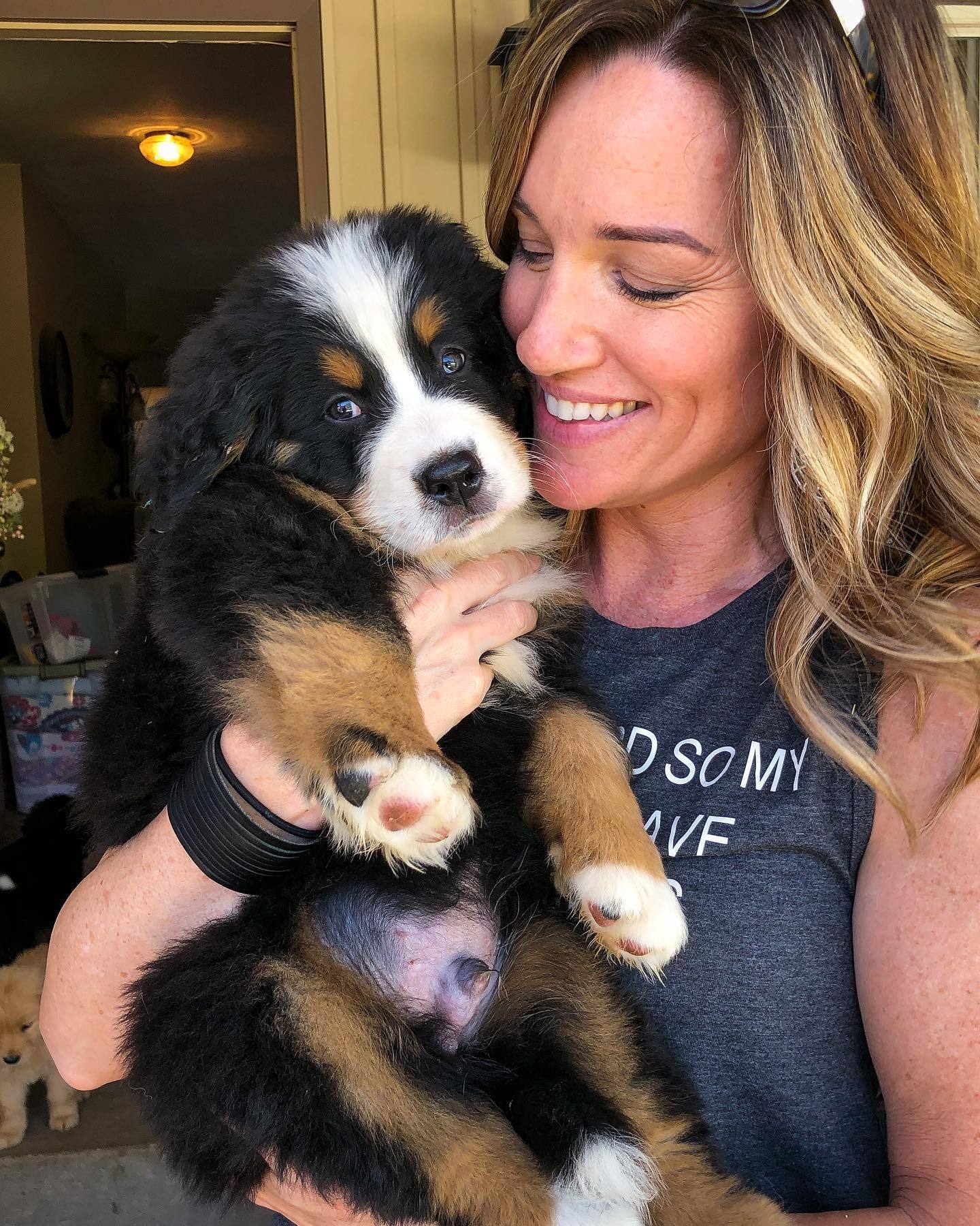 smiling woman with bernese puppy
