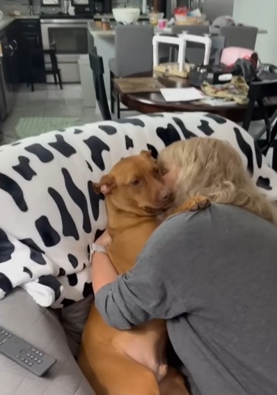 woman giving dog a kiss
