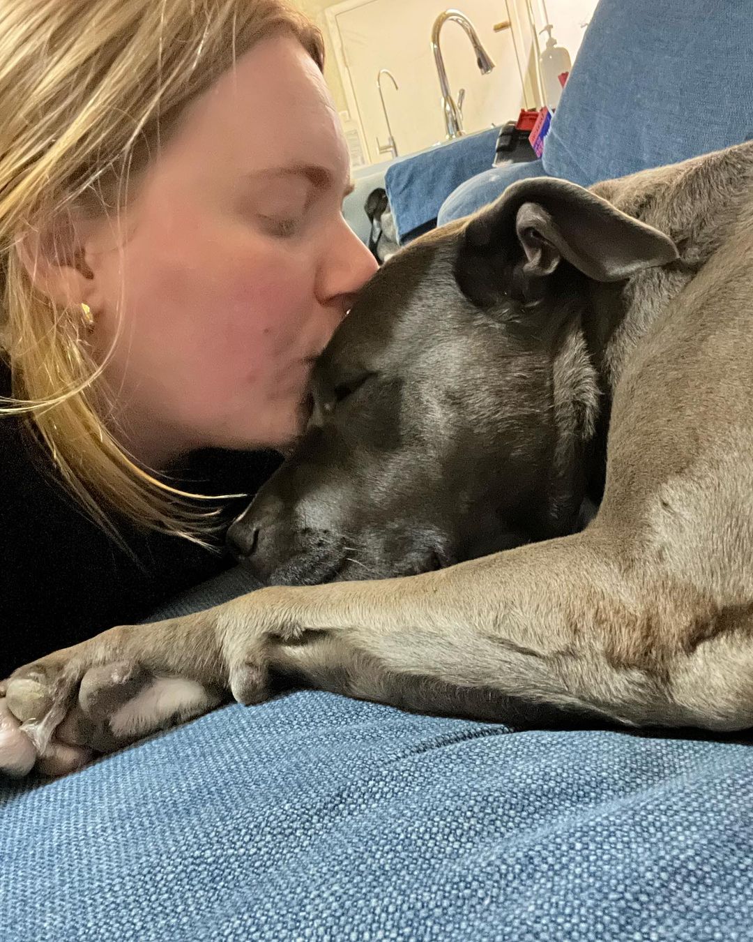 woman kissing dog on the head
