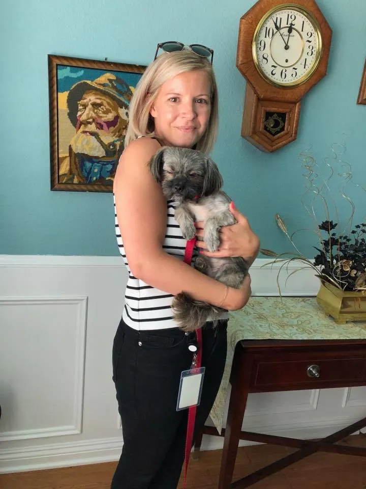 blonde woman holding a dog