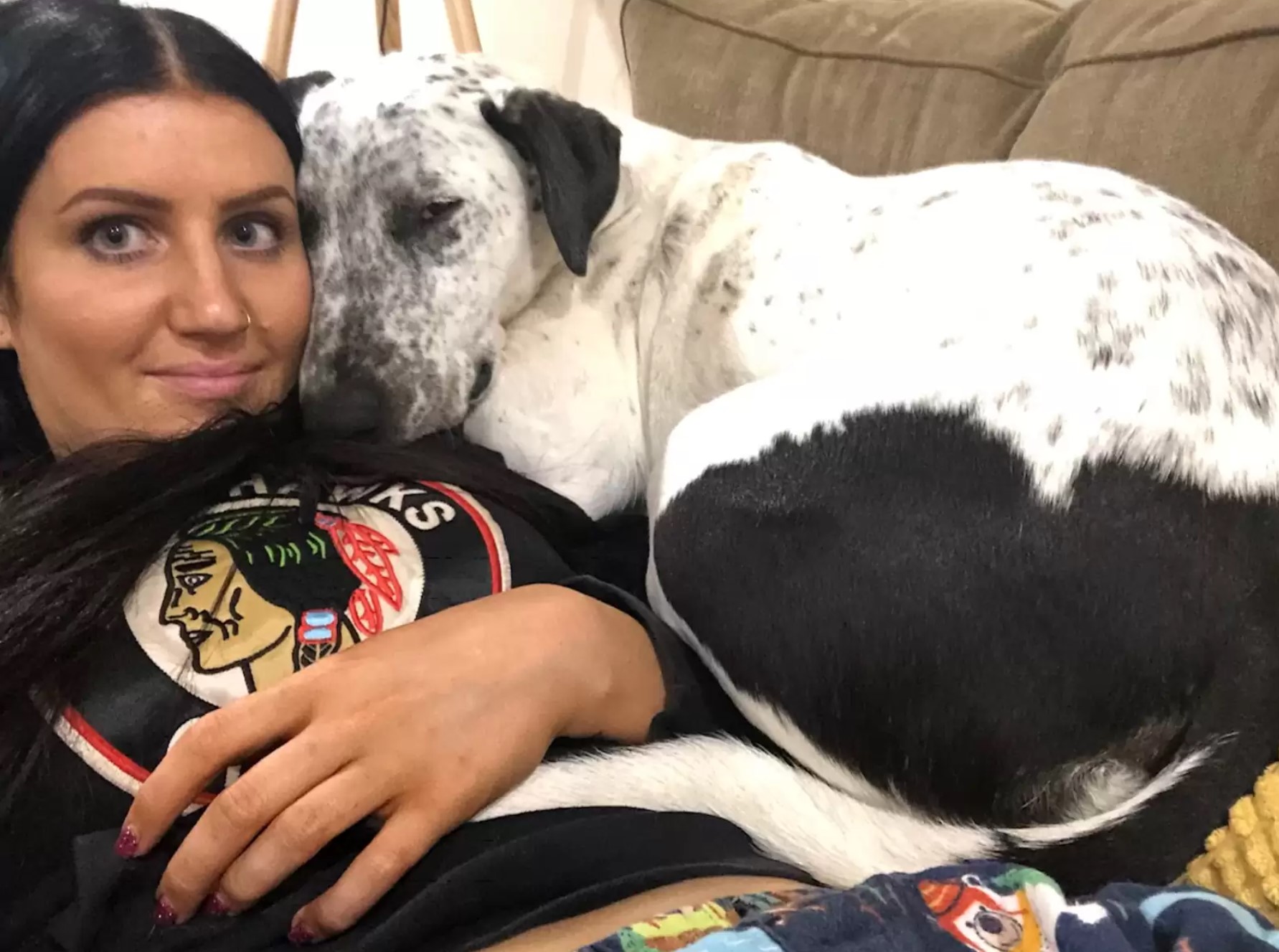 dog lying next to a woman