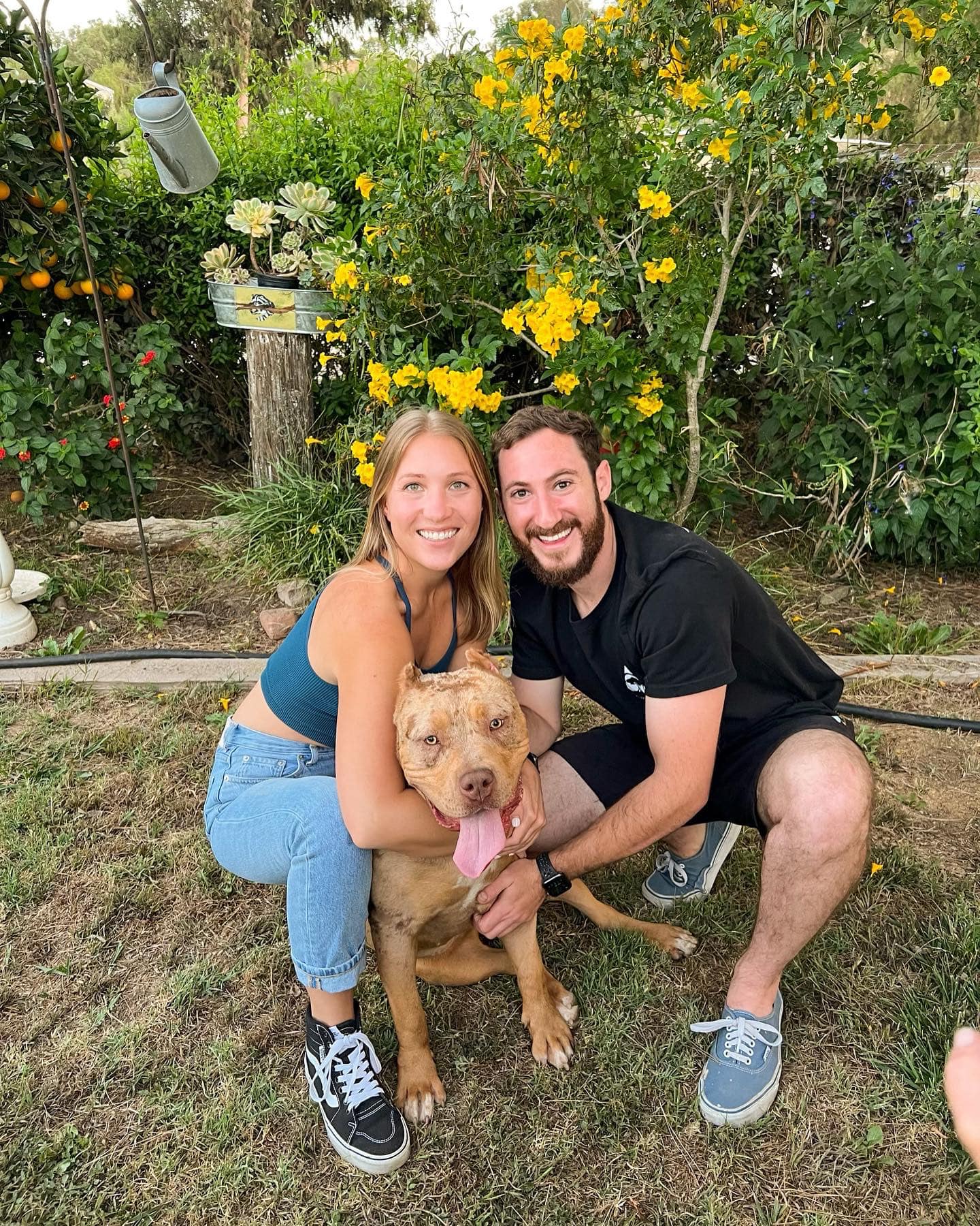 happy couple posing with pitbull
