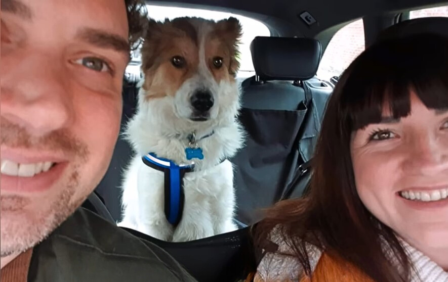 photo of couple and a dog in the car