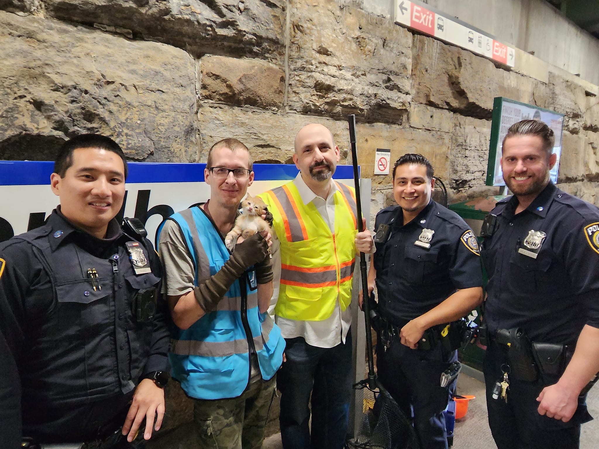 photo of rescuers and officers with kitten