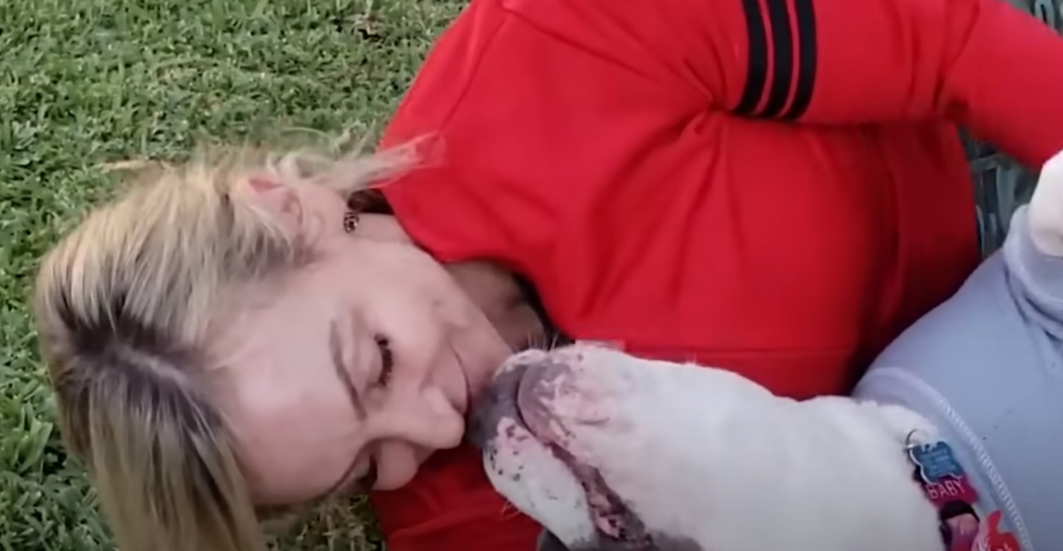 woman cuddling with a pitbull
