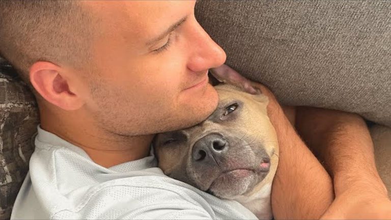 man cuddling with a dog