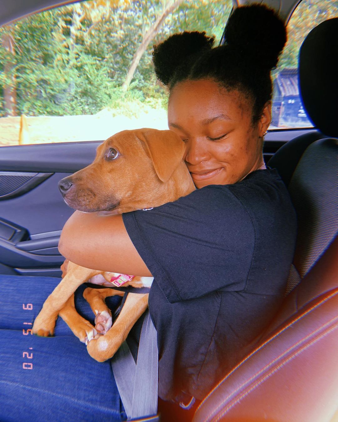Woman hugging her dog in the car