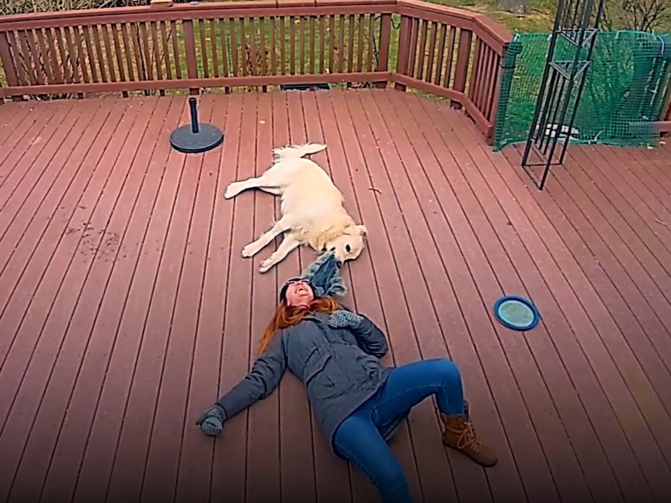 owner and dog laying on a terrace