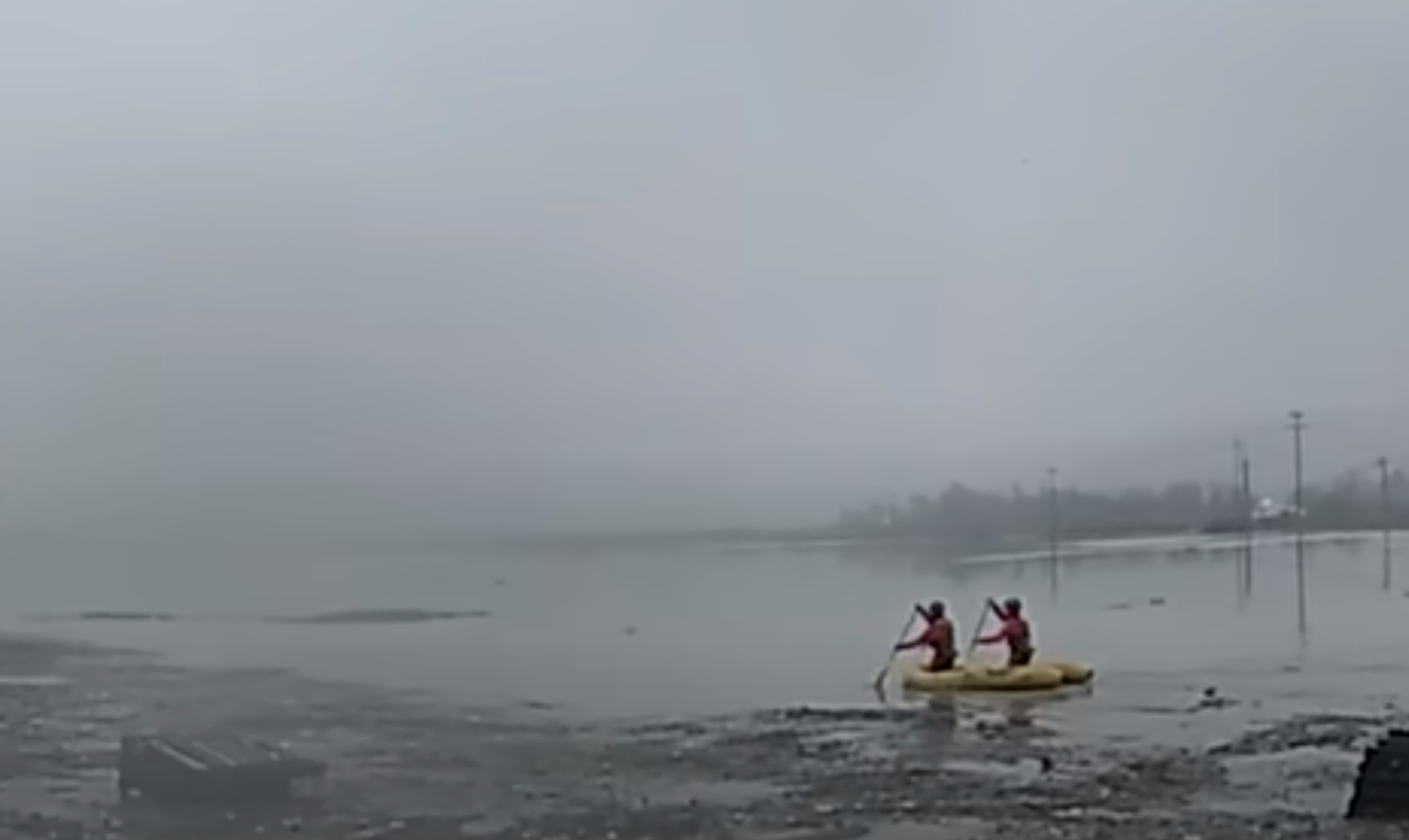 rescuers paddling in flooded river