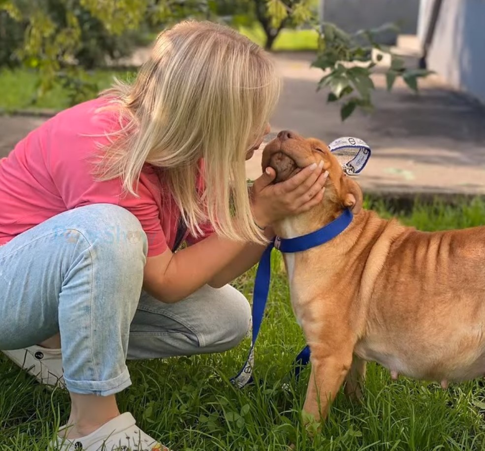 blond woman cuddling with dog