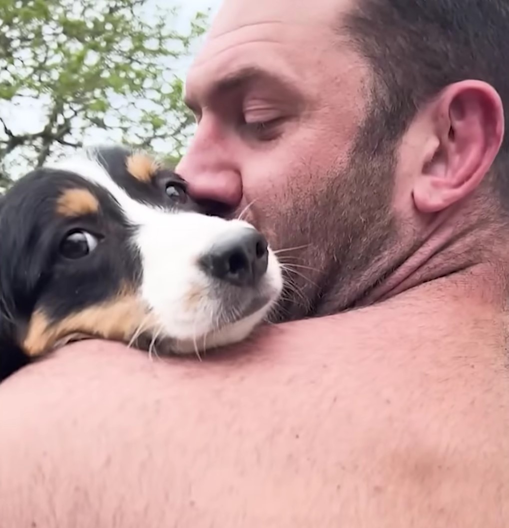guy holding and kissing dog