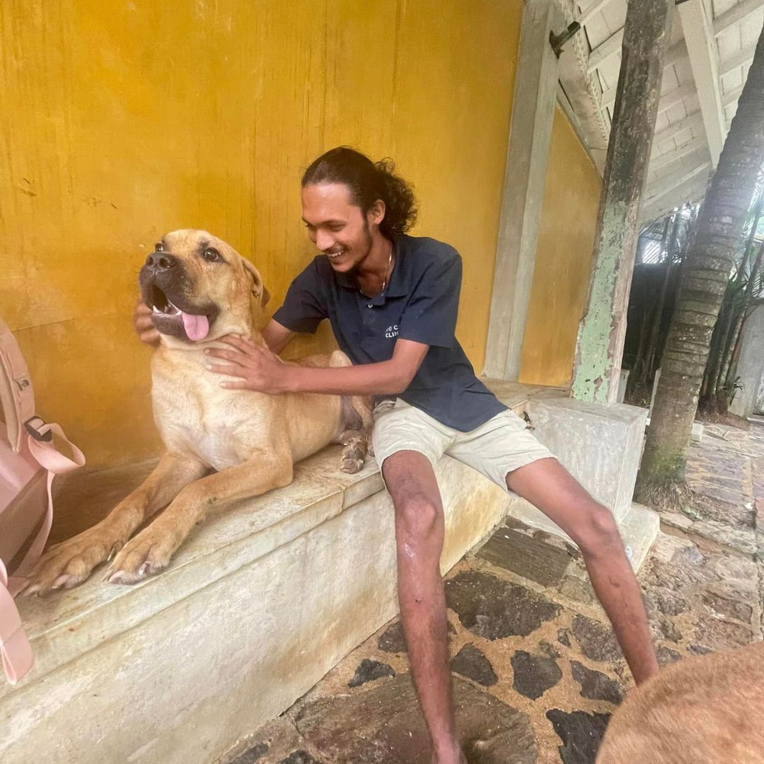 man sitting next to a dog